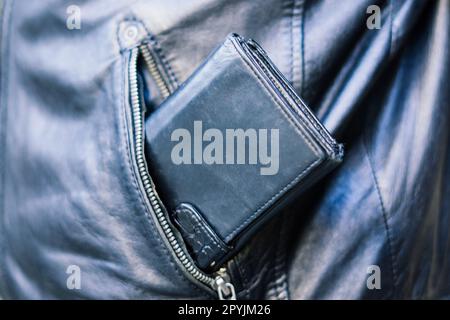 From the pocket of jacket the thief pulls out card banknote money purse wallet. Stock Photo