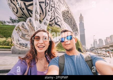 17 January 2023, Dubai, UAE: Adorable multicultural couple taking selfie photo on the background of Future Museum Stock Photo