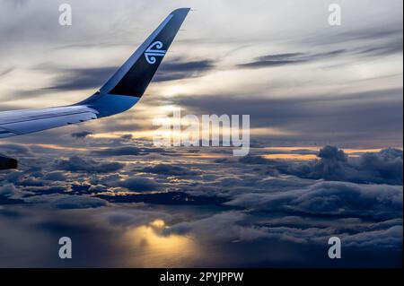 Wellington, New Zealand  - April 20, 2023: An Air New Zealand Aircraft Wing in the sky at sunset flying between Wellington and Christchurch on a natio Stock Photo