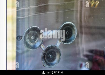 Industrial triple suction glass holder, mounted on a window plate on other side, closeup detail Stock Photo