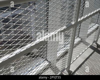 New white frames and windows. Metal fence for the safety of schoolchildren. New modern school. View from the window to the opposite wall and windows. Security systems. Internal office interior. Stock Photo