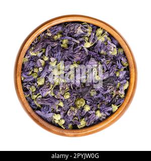 Dried purple mallow tea flowers, Malva sylvestris, in a wooden bowl Stock Photo