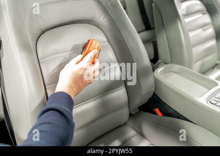 Closeup leather car interior cleaning with foam detergent and