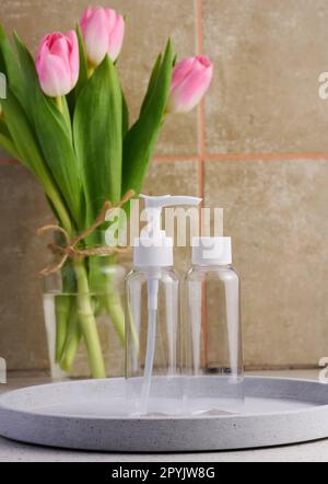 Transparent plastic container with a dispenser on the table. Bottle for liquid soap, shampoo Stock Photo