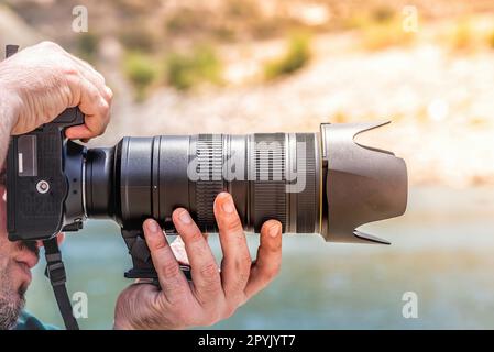 Side view of a photographer holding camera Stock Photo