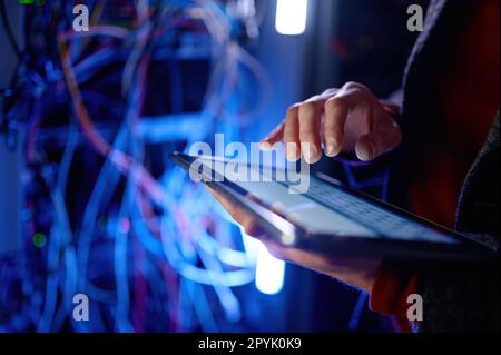 Closeup hand working in digital tablet in server room Stock Photo