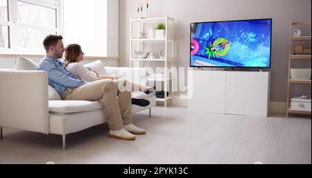 Rear View Of A Couple Watching Movie On Television Stock Photo