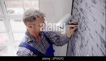 Close-up Of Technician Adjusting CCTV Camera Stock Photo