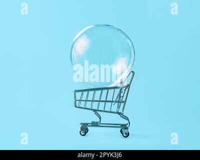 Shopping cart with soap bubble on blue background Stock Photo