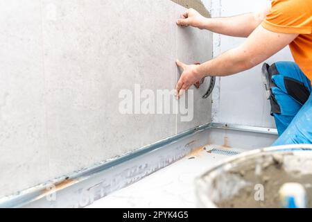 installation of large format tiles on the wall by a craftsman Stock Photo