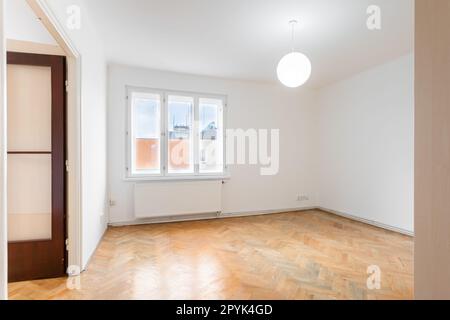an empty room in an apartment with a wardrobe and a wooden parquet floor Stock Photo