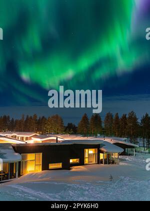 Aurora over a cottage in wintertime in Kuusamo, Finland Stock Photo