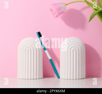 Blue plastic toothbrush on pink background Stock Photo
