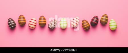 Chocolate easter eggs on pink background. Top view. Stock Photo