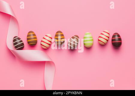 Chocolate easter eggs on pink background. Top view. Stock Photo