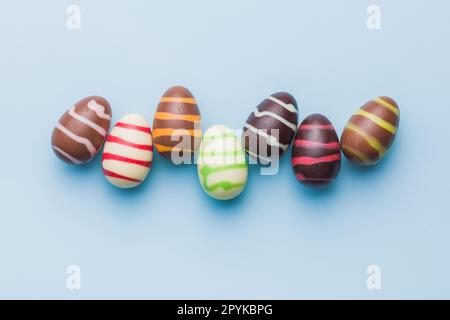 Chocolate easter eggs on blue background. Top view. Stock Photo