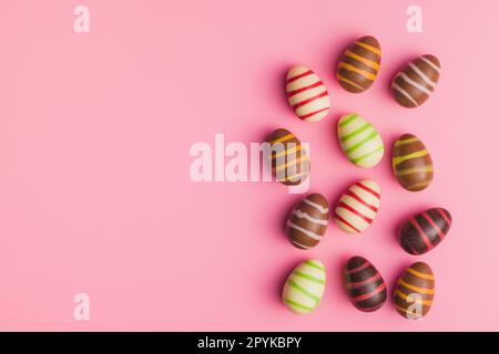 Chocolate easter eggs on pink background. Top view. Stock Photo