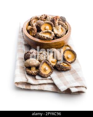 Dried shiitake mushrooms on checkered napkin isolated on white background. Stock Photo