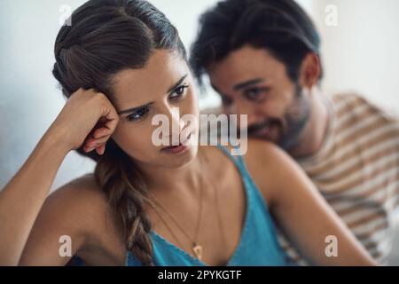 Approach with caution. a young couple having an argument while sitting on their couch at home. Stock Photo