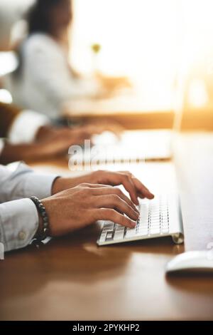Let the fingers do the talking. an unrecognizable man typing on a keyboard. Stock Photo