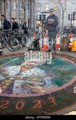 As Coronation Day approaches, an artist masterfully paints King Charles III on the ground. Stock Photo