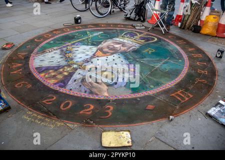 As Coronation Day approaches, an artist masterfully paints King Charles III on the ground. Stock Photo