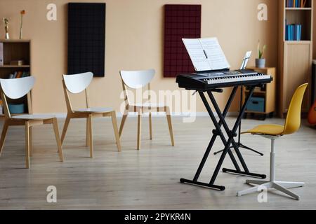 Horizontal image of empty music class with synthesizer and sheet music for playing music Stock Photo