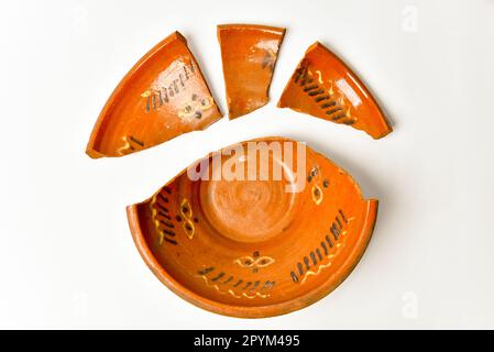 Broken porcelain kitchenware top view. Cracked ceramics plate on white background. Stock Photo