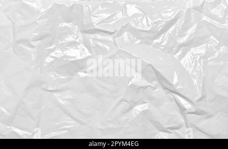 Crumpled white plastic bag texture. Polypropylene recyclable packaging backdrop. Wrinkled cellophane package background. Stock Photo