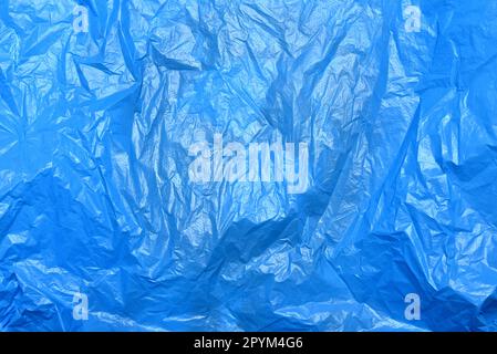 Polypropylene recyclable packaging backdrop. Wrinkled cellophane package background. Crumpled blue plastic bag texture. Stock Photo