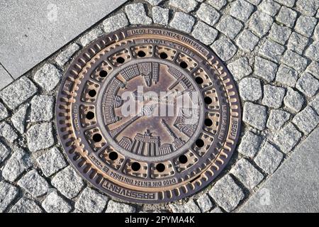 Intricate waterboard manhole cover in a street in Berlin Stock Photo
