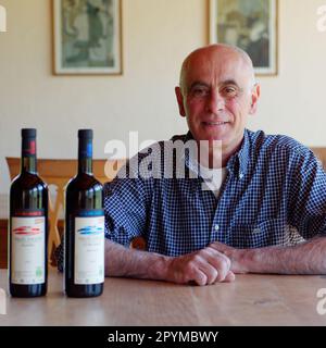 Owner of Les Granges vineyard in Aosta Valley, NW Italy, together with bottles of wine Stock Photo