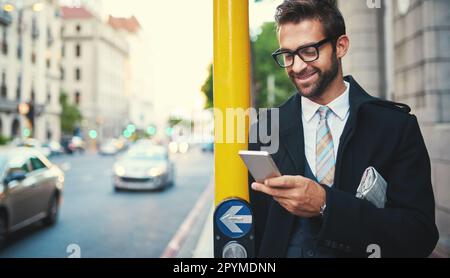 Staying connected in the concrete jungle. a stylish man using his phone in the city. Stock Photo