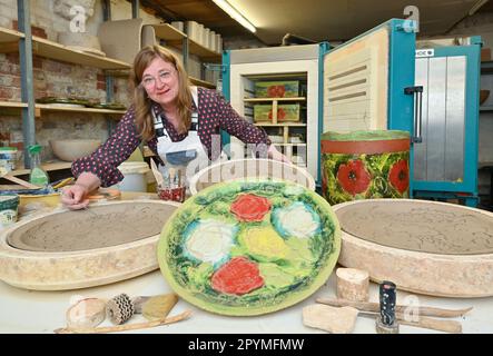 04 May 2023, Brandenburg, Sieversdorf: Undine Gomille, artist, stands in her workshop at an open kiln with ceramics and prepares the space for the 'Open Studio Days'. The first weekend in May has become a fixed date for many art enthusiasts during the past years. On May 06 and 07, 2023, artists will again open their studios in Brandenburg's counties and independent cities. Those who like can discover painting, graphics and book art directly at the place of origin, can look over the shoulder of sculptors and ceramic artists, learn to understand printing techniques and in some places even get th Stock Photo