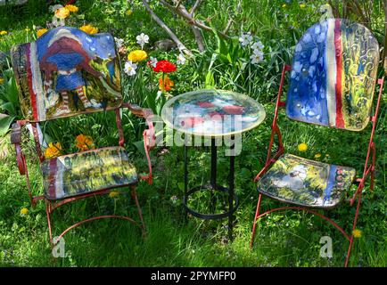 04 May 2023, Brandenburg, Sieversdorf: In the garden of the artist Undine Gomille, two chairs and a table made of ceramics are ready for visitors to the 'Open Studio Days'. The first weekend in May has become a fixed date for many art lovers during the past years. On May 06 and 07, 2023, artists will again open their studios in Brandenburg's counties and independent cities. Those who like can discover painting, graphics and book art directly at the place of origin, can look over the shoulder of sculptors and ceramic artists, learn to understand printing techniques and in some places even get t Stock Photo