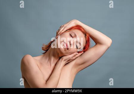 woman stretches her neck muscles with her hands, turned her head to one side. Stretching, relaxation Stock Photo