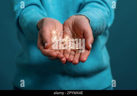 Light garland in women hands. Light bulbs in hands Stock Photo
