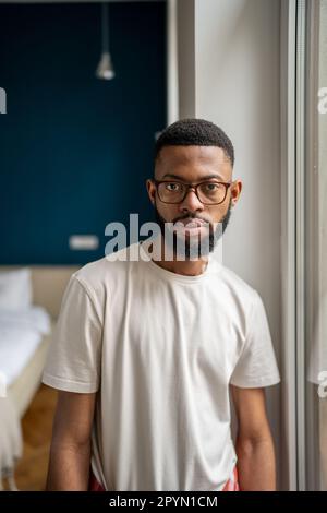 Serious young African American man homeowner posing in apartment Stock Photo