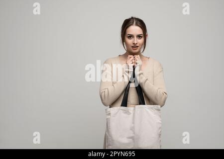 Young blonde woman in the white t-shirt with headphones listening music .Music teenager girl dancing against isolated blue background. Stock Photo