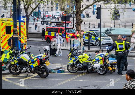 London, UK. 4th May, 2023. Emergency services including Ambulance Crews from the London Ambulance Service and motorcycle police attend an injured man on the road next to Trafalgar Square. The build up to the coronation means that central london is flooded with police and ambulances for security and safety. Credit: Guy Bell/Alamy Live News Stock Photo