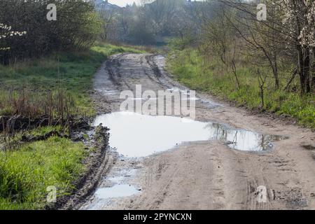 Mud, puddles, a country road after rain. Soggy ground. Stock Photo