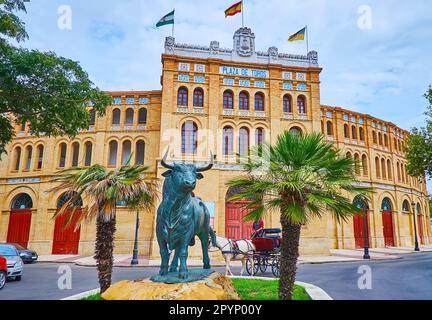 The statue of the bull in front of the portal of historic bullring, located on Plaza de Toros, El Puerto, Spain Stock Photo