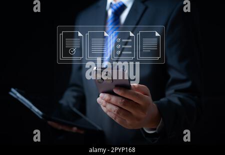 Businessman using smartphone with document, Online documentation Stock Photo