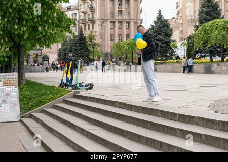 A man seen with Ukrainian national colors balloons on Maidan Square in Kyiv, Ukraine on May 4, 2023 Stock Photo