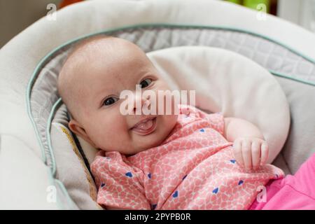 Happy Caucasian baby girl sticking her tongue out Stock Photo