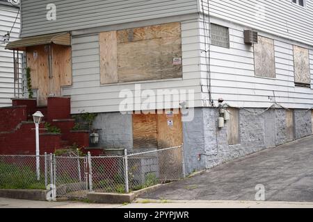 Bronx, NY - May 3, 2023: Boarded up door and windows of New York City suburb residential home Stock Photo