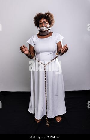 Portrait of a black woman in chains with an iron mask over her mouth.  Slavery in Brazil. Studio reproduction Stock Photo - Alamy