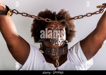 Portrait of a black woman in chains with an iron mask over her mouth.  Slavery in Brazil. Studio reproduction Stock Photo - Alamy