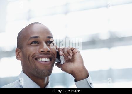 Talking my way to the top. A handsome african businessman, talking on his cellphone and smiling. Stock Photo