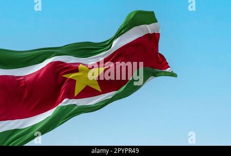 Suriname national flag waving in the wind on a clear day. 5 horizontal bands: green, white, red, white, green, yellow star in the center. 3D illustrat Stock Photo